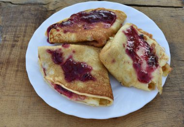 Dokulu bir ahşap tahta arka plan üzerinde reçelli krep.