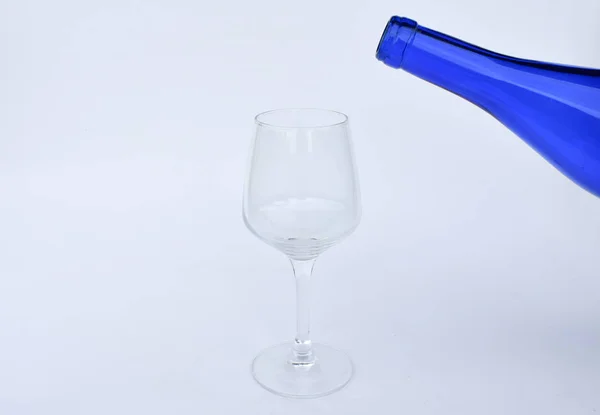 Vidrio Vacío Con Una Botella Azul Encima —  Fotos de Stock