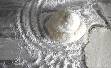 Gri doku arka plan. Masanın üzerinde dağınık un ile hamur parçası.
