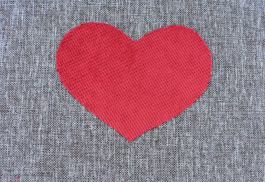 Kırmızı kalp bez gri bir tuval üzerine yapılmış