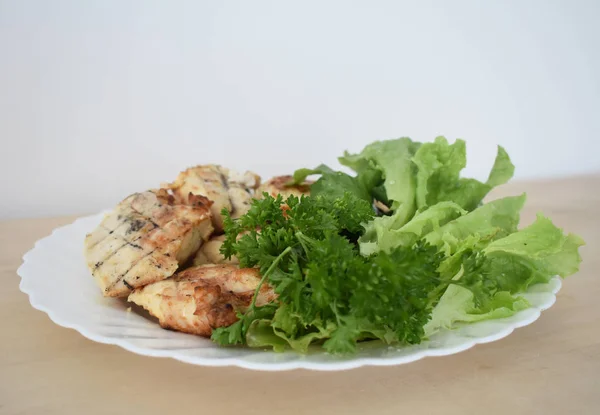 Shish kebab on a plate with greens
