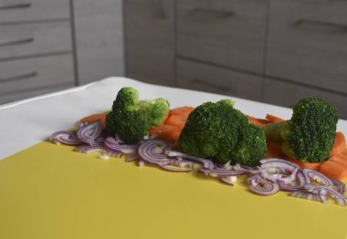 Parlak sarı arka plan üzerinde Dilimleme sebze.