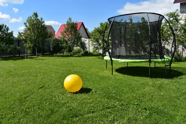 Trampolino sul prato con palla gialla .. — Foto Stock