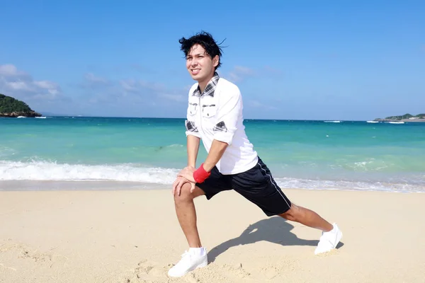 Азиатский Мужчина Растянувшийся Пляже — стоковое фото