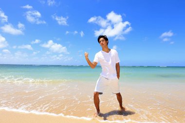 Sahilde gülümseyen Asyalı adam