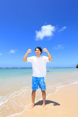 Sahilde gülümseyen Asyalı adam