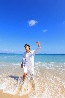 Sahilde gülümseyen Asyalı adam