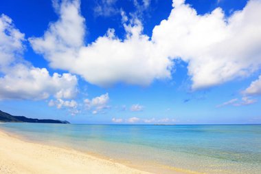 Yaz gökyüzü ve Okinawa 'nın güzel plajı