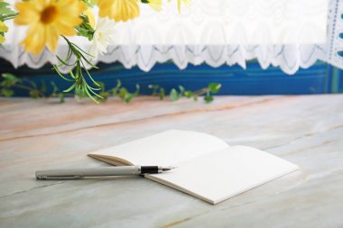 defter ve kalem masanın üstüne.