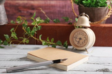 Masanın üzerinde defter ve dolma kalem