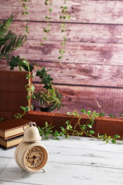 Masadaki kitap ve çalar saat yığını