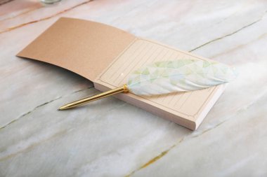 Masanın üzerinde memo pad ve quill kalem