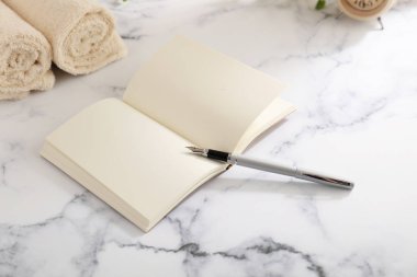 Masanın üzerinde defter ve dolma kalem