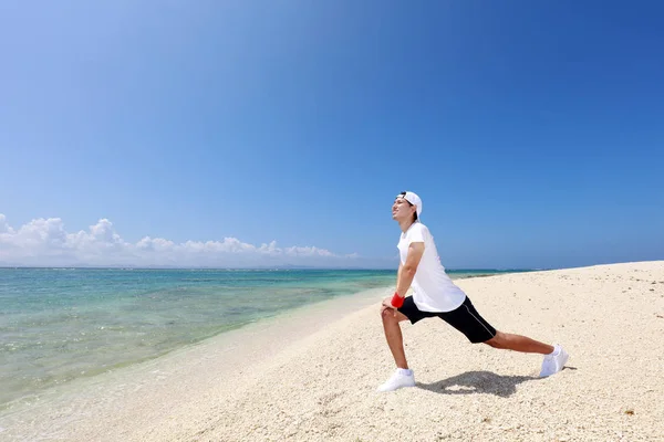 Asiatico Giovane Uomo Stretching Spiaggia — Foto Stock