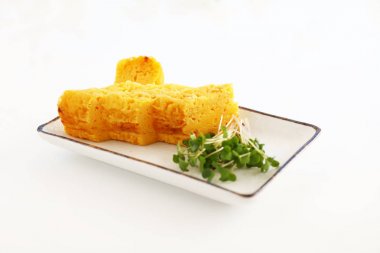 Japonlar yemek masasında bir tabakta omlet haddelenmiş