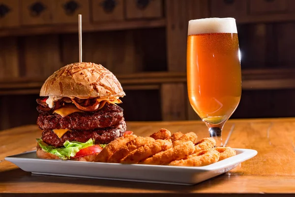 Ahşap masa hamburger duble burger peynir pastırma domates marul bira soğan halkaları