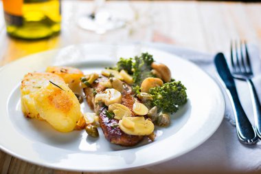 Limon lezzet soslu ızgara tilapia fileto, kavrulmuş patates dilimleri ve sote brokoli ve mantar