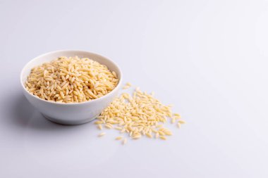 Beyaz seramik bolw Orzo makarna, beyaz arka plan üzerinde izole. Pirinç taneleri şeklinde İtalyan orzo makarna