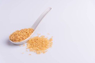 Beyaz arka plan üzerinde beyaz bir kaşık ham kahverengi pirinç açı görünümü