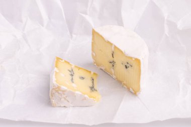 Beyaz yüzeyli mavi peynir, beyaz arka plan, yumuşak ışık, stüdyo fotoğrafı, açı görünümü üzerine izole. Gorgonzola ve camembert / brie peynir karışımı