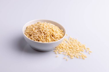 Beyaz seramik bolw Orzo makarna, beyaz arka plan üzerinde izole. Pirinç taneleri şeklinde İtalyan orzo makarna
