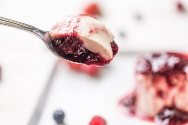 Berry soslu lezzetli İtalyan tatlı panna cotta, beyaz ahşap arka plan taze çilek