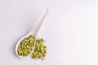 Beyaz seramik kaşıkta bölünmüş kurutulmuş pişmemiş bezelye