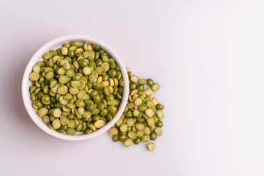 Beyaz seramik kase bölünmüş kurutulmuş pişmemiş bezelye üst görünümü