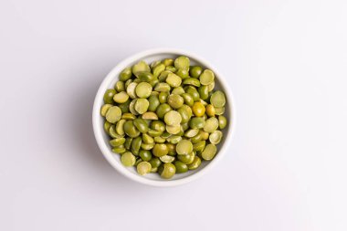 Beyaz bir seramik kapta bölünmüş kurutulmuş pişmemiş bezelye açı görünümü