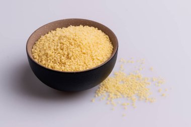 Beyaz arka plan üzerine izole kahverengi seramik kase kuru kuskus