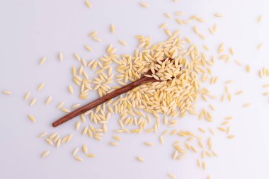 Tahta bir kaşıkta Orzo makarna, beyaz arka plan üzerinde izole. Pirinç taneleri şeklinde İtalyan orzo makarna