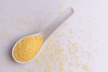 Beyaz arka plan üzerine izole beyaz seramik kaşık kuru kuskus