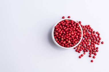 Pembe Biber Beyaz kase, Brezilya Biber, Gül biber, beyaz arka plan üzerinde Schinus terebinthifolius tohumları