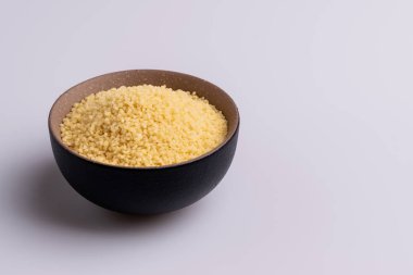 Beyaz arka plan üzerine izole kahverengi seramik kase kuru kuskus