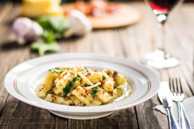 Ahşap beyaz arka plan üzerinde beyaz plaka karbonara soslu Penne makarna