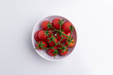 Üst görünüm üzüm veya kiraz domates dalı. Beyaz kapta kırmızı üzüm domates kazık, beyaz arka plan üzerinde izole