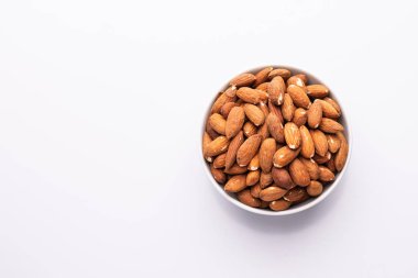 Beyaz bir kapta badem fındık yığını, beyaz arka plan üzerinde izole