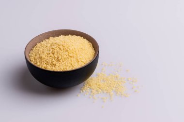 Beyaz arka plan üzerine izole kahverengi seramik kase kuru kuskus