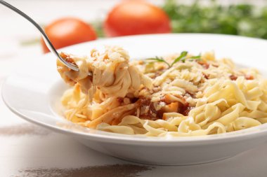 Rustik ahşap masa arka plan üzerinde beyaz bir tabak domates soslu Makarna Fettuccine Bolonya