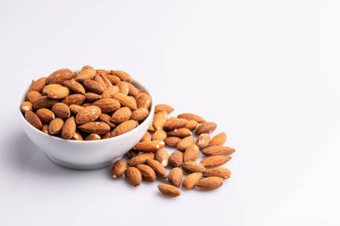 Beyaz bir kapta badem fındık yığını, beyaz arka plan üzerinde izole