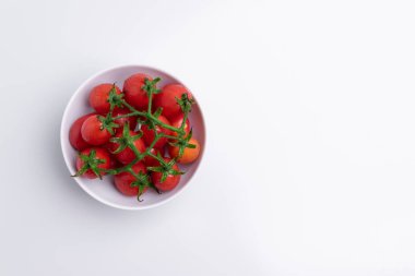 Üst görünüm üzüm veya kiraz domates dalı. Beyaz kapta kırmızı üzüm domates kazık, beyaz arka plan üzerinde izole