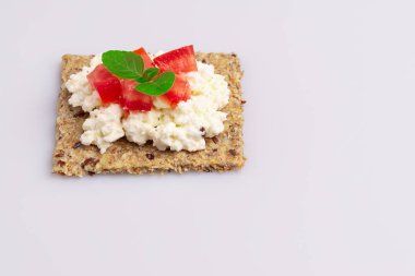 Ricotta peyniri, domates ve otlar beyaz arka plan üzerinde izole diyet keten tohumu kepekli kraker
