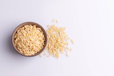Siyah seramik bolw Orzo makarna, beyaz arka plan üzerinde izole. Pirinç taneleri şeklinde İtalyan orzo makarna