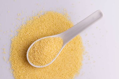 Beyaz arka plan üzerine izole beyaz seramik kaşık kuru kuskus