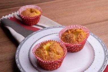 Brezilya yemeği. Queijadinha - tipik brezilya tatlı peynir, hindistan cevizi, yumurta, tereyağı, buğday, kabartma tozu ve ahşap arka plan üzerinde şeker ile yapılan