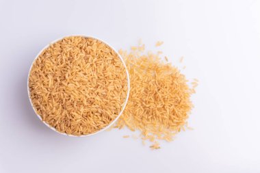 Beyaz arka plan, açı görünümü üzerinde beyaz bir kapta Raw Brown Rice üst görünümü. İntegral Kepekli Tahıl. Latince terim Oryza sativa da Tüm Çin Pirinç tohumu olarak bilinen