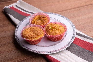Brezilya yemeği. Queijadinha - tipik brezilya tatlı peynir, hindistan cevizi, yumurta, tereyağı, buğday, kabartma tozu ve ahşap arka plan üzerinde şeker ile yapılan