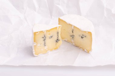 Beyaz yüzeyli mavi peynir, beyaz arka plan, yumuşak ışık, stüdyo fotoğrafı, açı görünümü üzerine izole. Gorgonzola ve camembert / brie peynir karışımı
