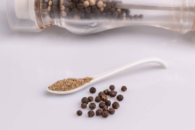 Beyaz arka plan üzerinde izole beyaz bir kaşık karabiber.