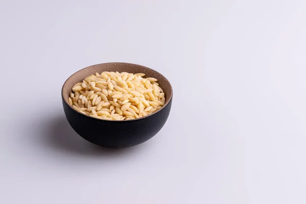 Pâtes Orzo Dans Boulon Céramique Noire Isolé Sur Fond Blanc — Photo